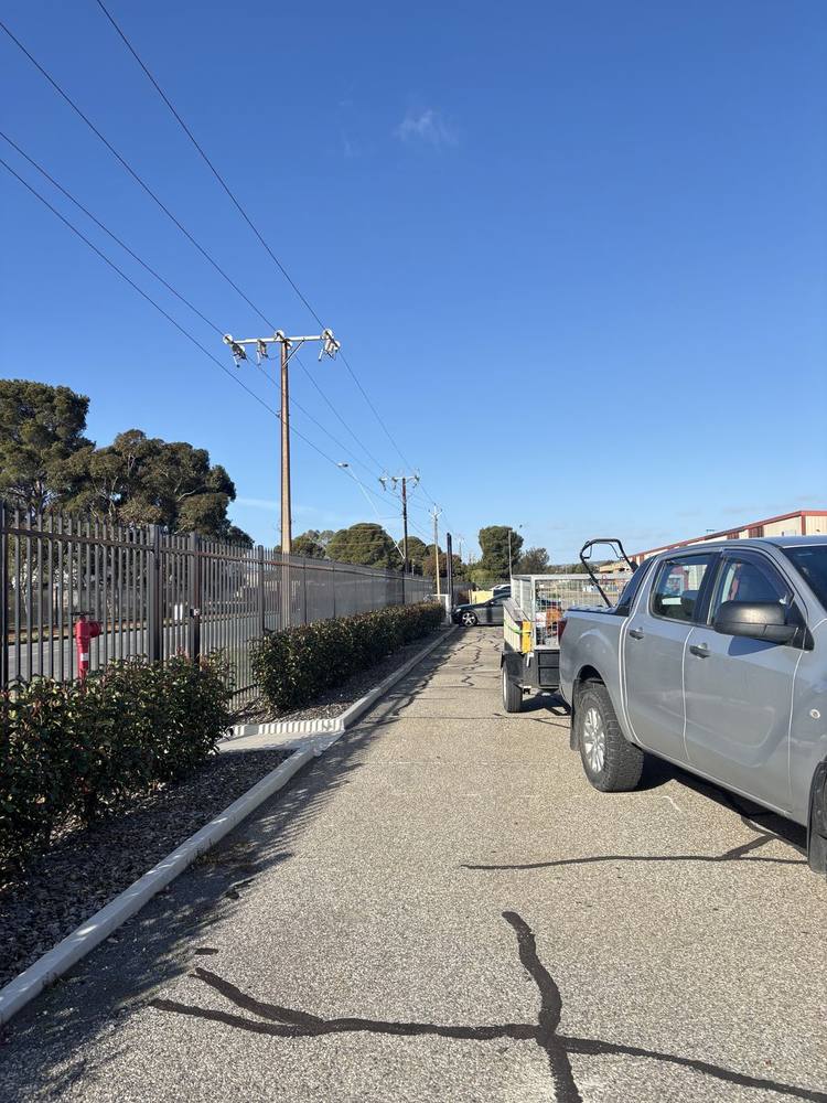 Hedged garden strip along an industrial site fence